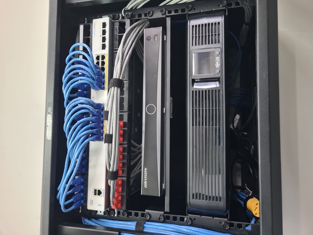 Switch Cisco, NVR Hikvision y UPS instalados en rack