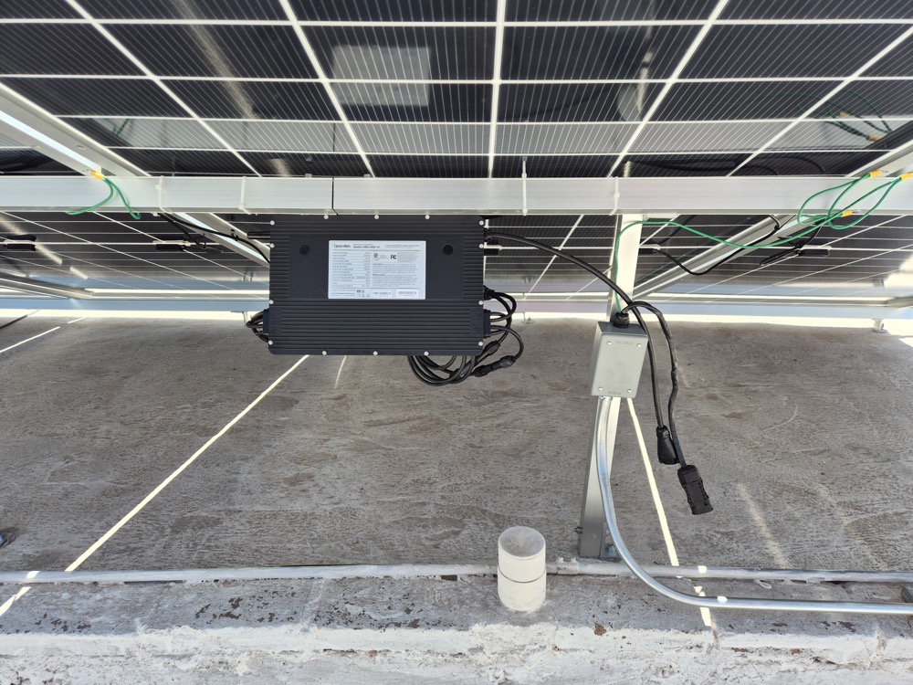Microinversor Hoymiles montado bajo panel solar